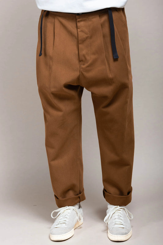Straight shot of male model wearing caramel patton pants and sneakers