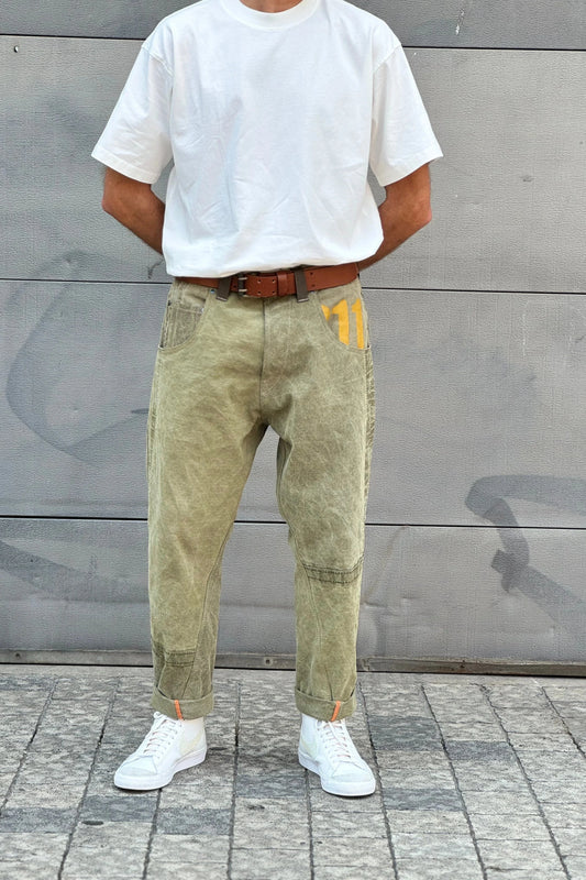 Full body shot of a person in a white tee and army carrot pants