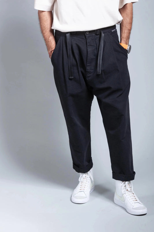Model wearing black pants, white t-shirt, and white sneakers, shot from the waist down