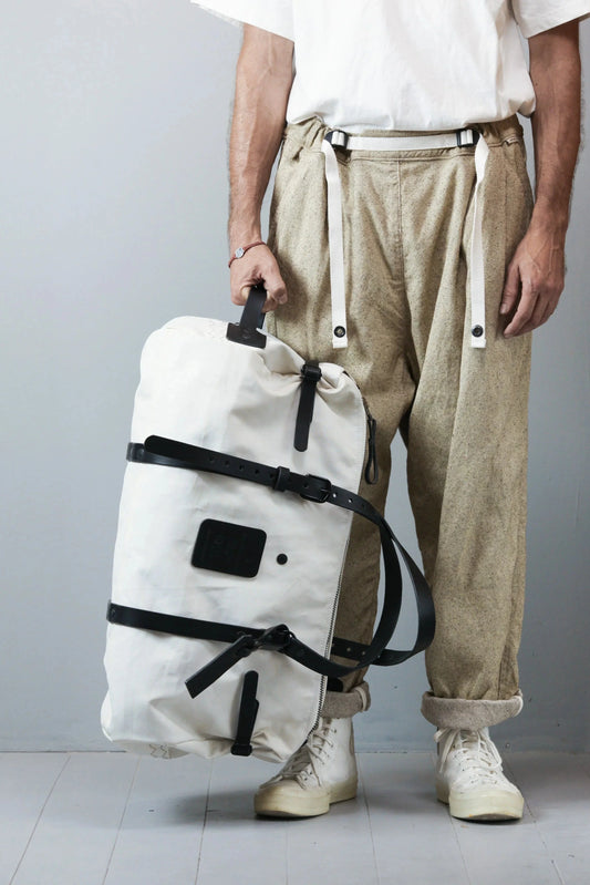Model wearing WEEKENDER SAIL bag, light cotton pants, white t-shirt and sneakers