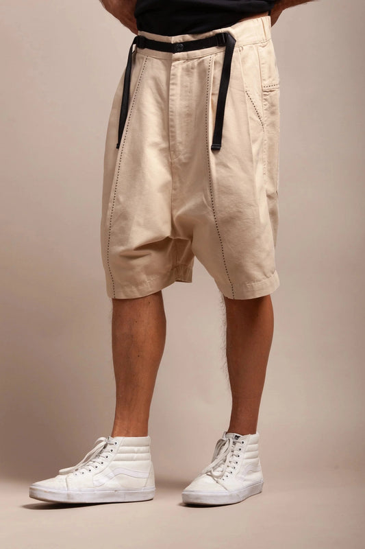 Model wearing bone patton shorts and white hightop sneakers from side angle