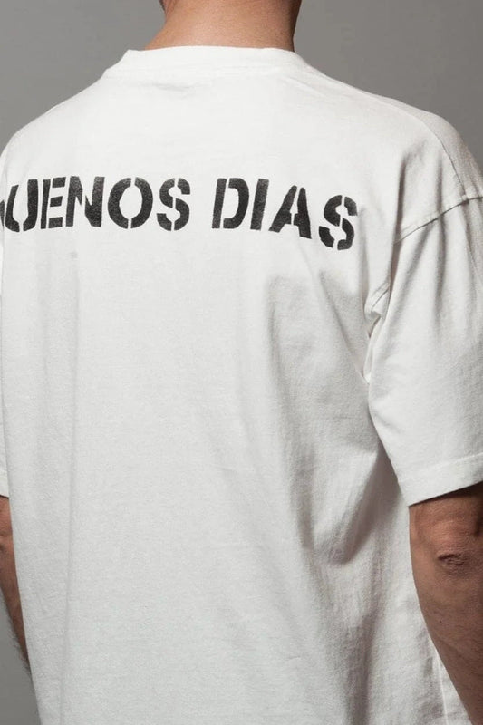 Rear view of model wearing white t-shirt with "BUENOS DÍAS" in black print
