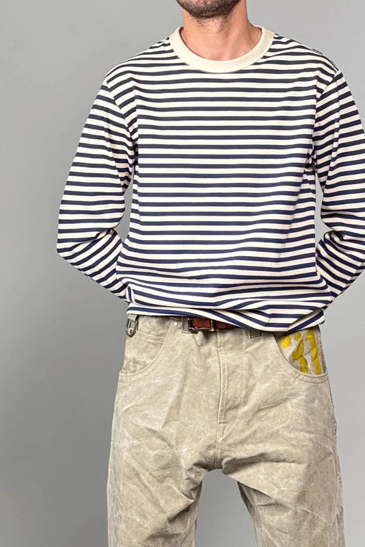 Model wearing a navy and white striped long-sleeve shirt and beige pants