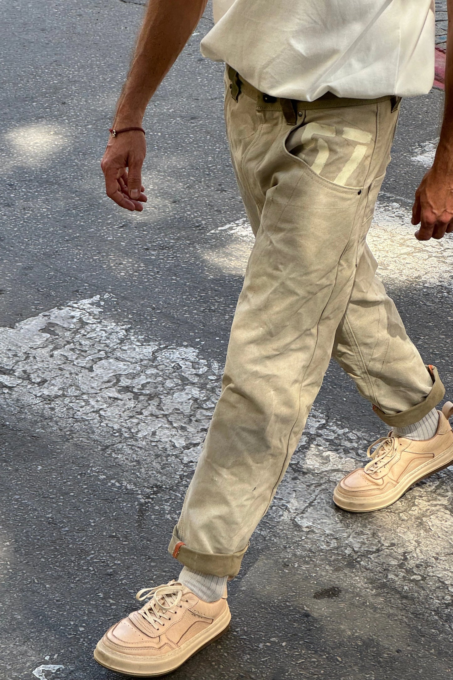 Torso, legs, and shoes in the sun on an asphalt background
