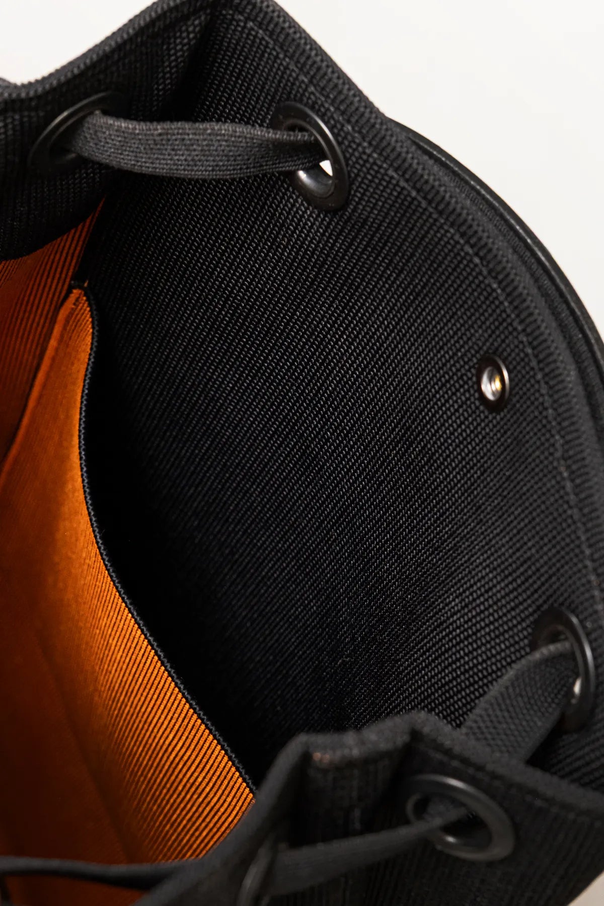 Close-up of black backpack interior with orange lining and drawstring details