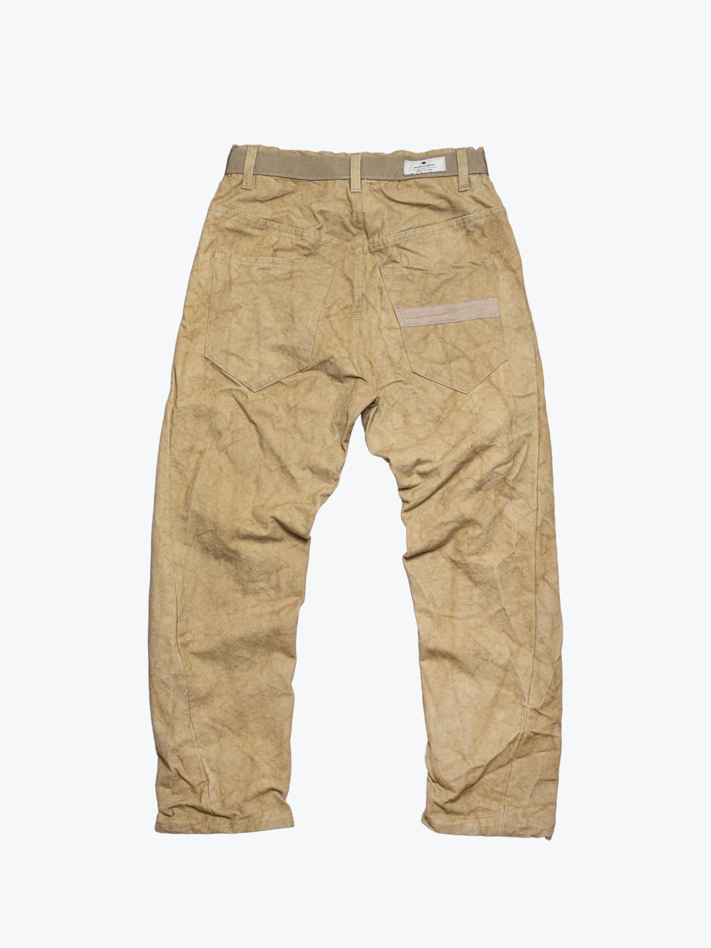 Back view of beige utility-style pants with visible stitching, belt loops, and two rear pockets, made from textured fabric suggesting durable, handcrafted menswear.