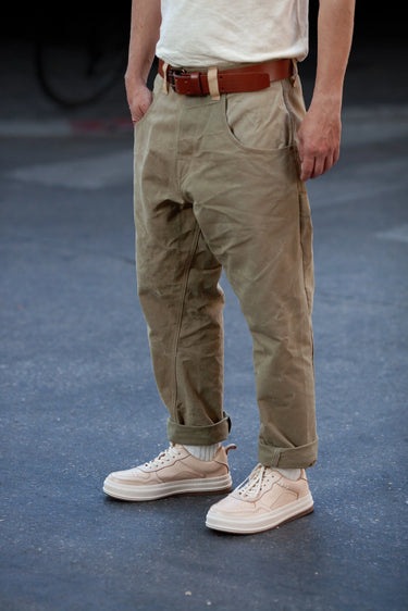 Full shot of model wearing beige sneakers with rolled-up cargo pants