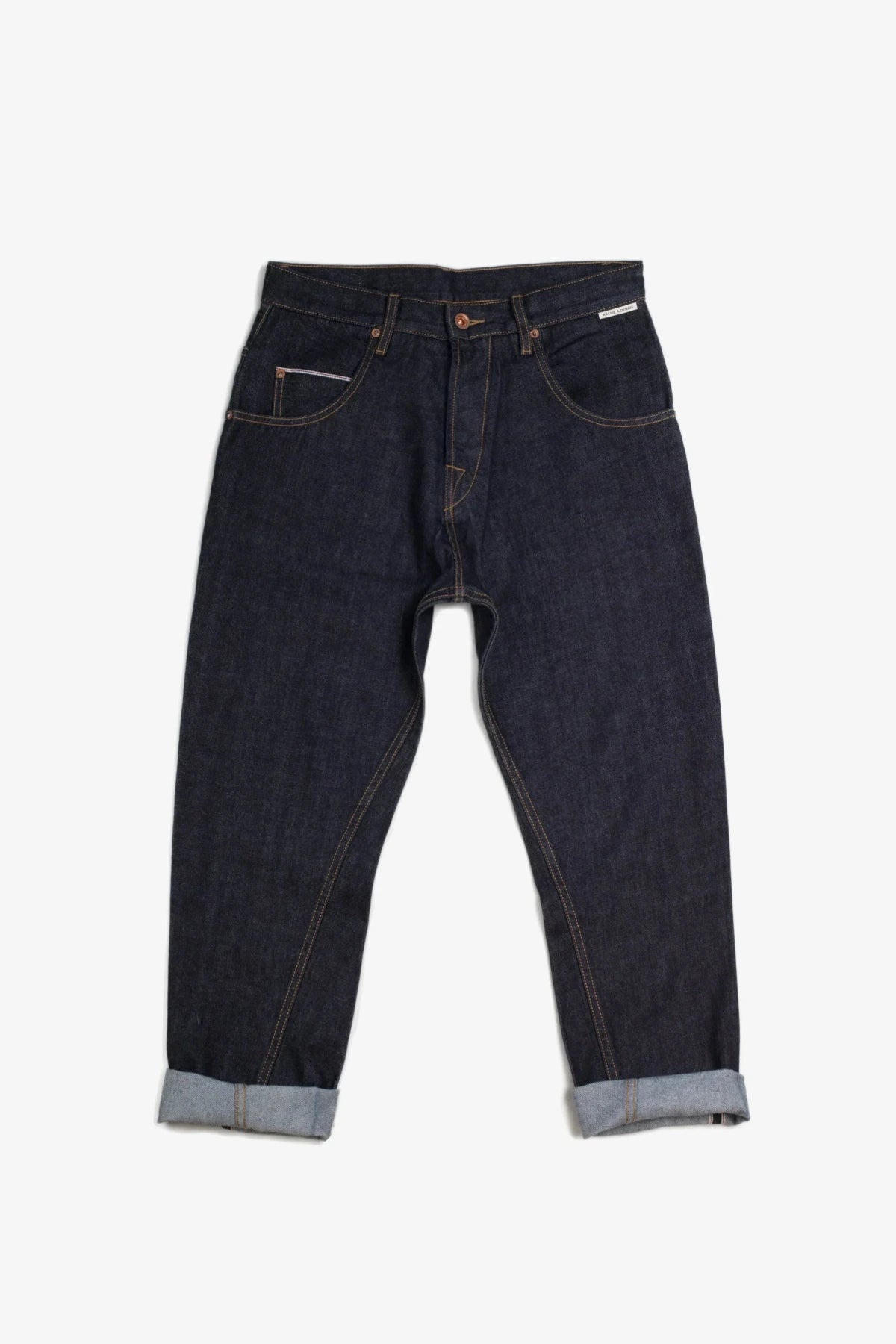 Dark wash denim pants with cuffed hems, laid flat on a white background