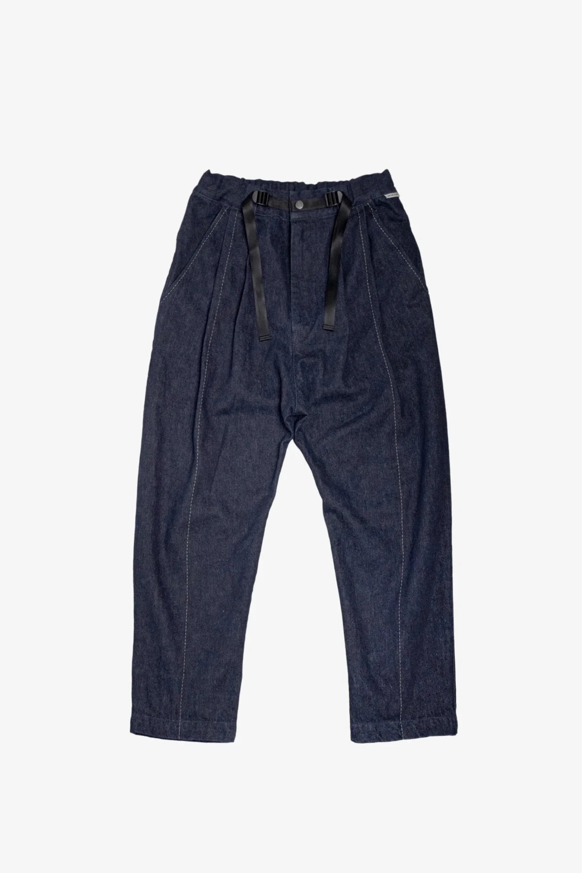 Dark denim drop-crotch pants with a black webbing belt on white background