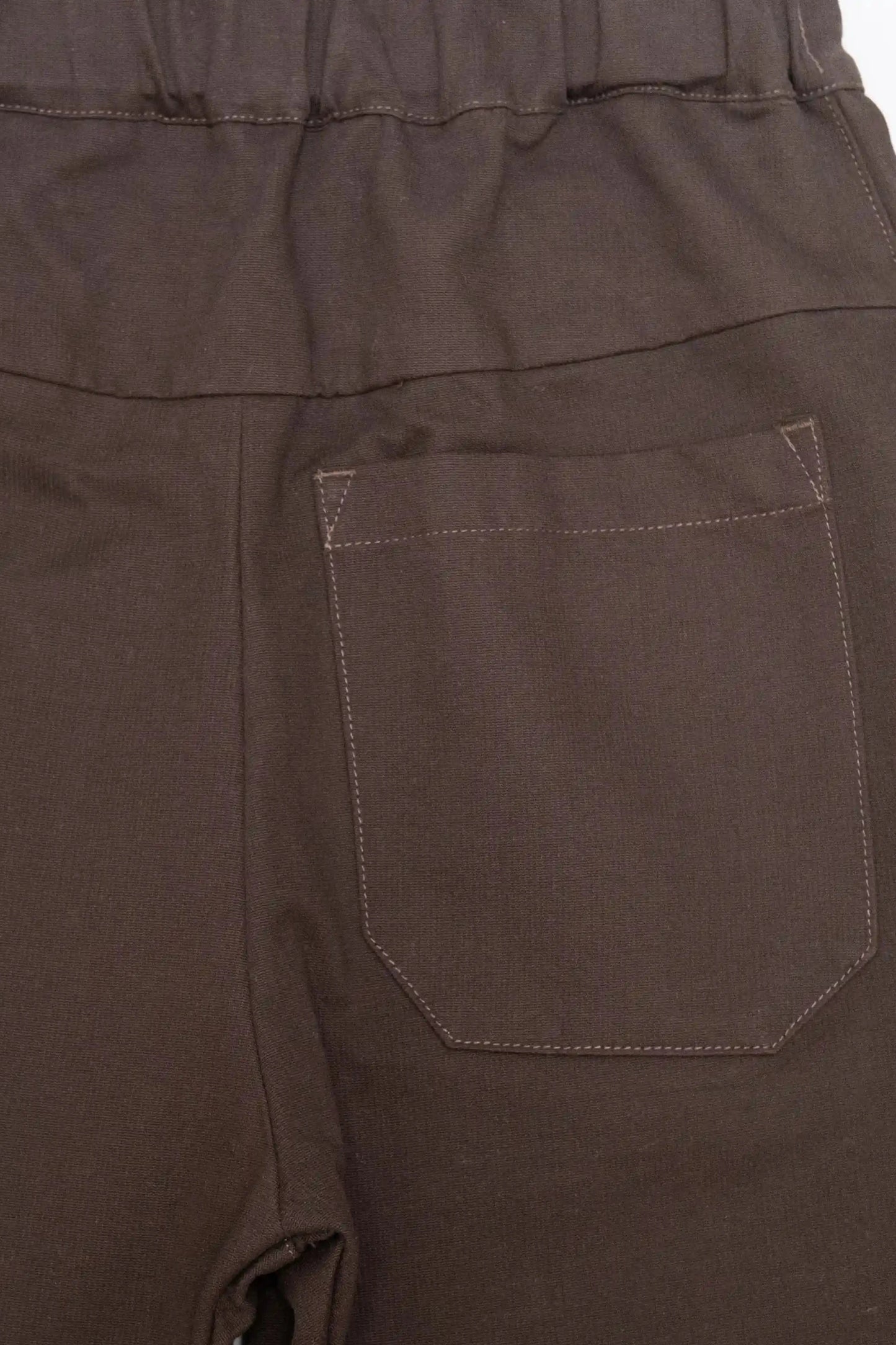 Close-up of the back pocket area on brushed brown pants featuring durable stitching and an elastic waistband, showcasing a utility-inspired, relaxed fit design.